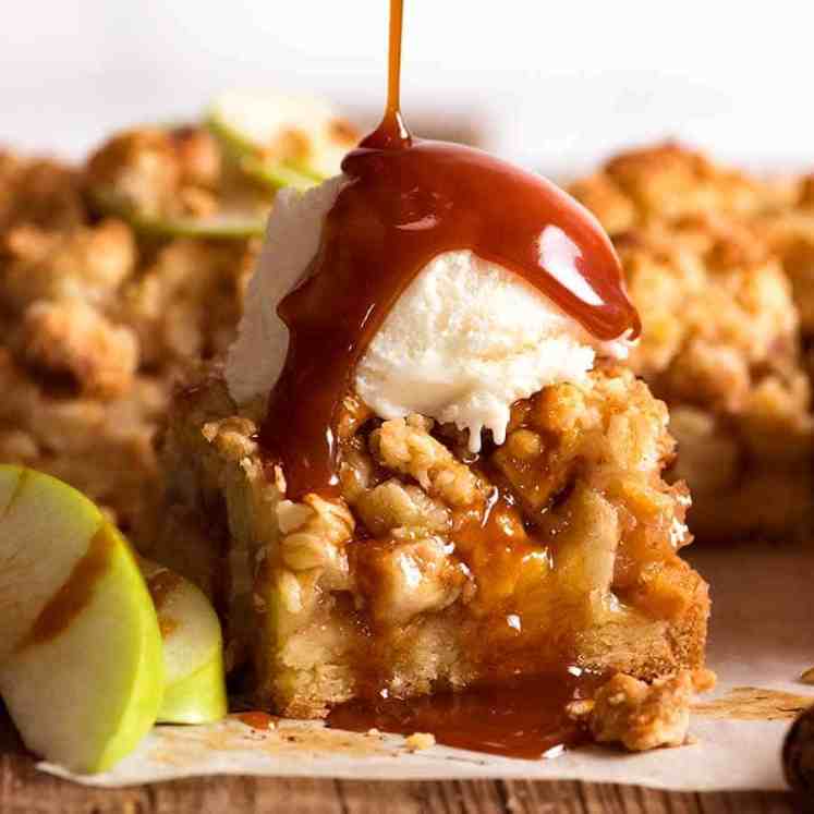 Apple Crumble Bars with ice cream and salted caramel sauce being drizzled over
