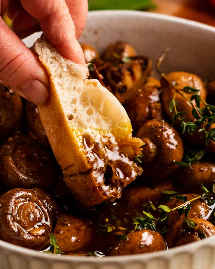 Dipping bread into the juices of Balsamic marinated mushrooms