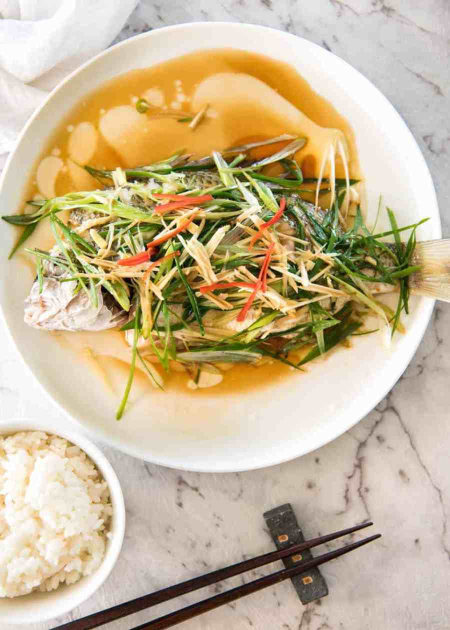 A Chinese Steamed Fish topped with Ginger and Shallots and seasonings, with hot oil poured over it to create a dramatic sizzle and an amazing sauce. So simple, yet so utterly delicious. Steam OR bake the fish! recipetineats.com
