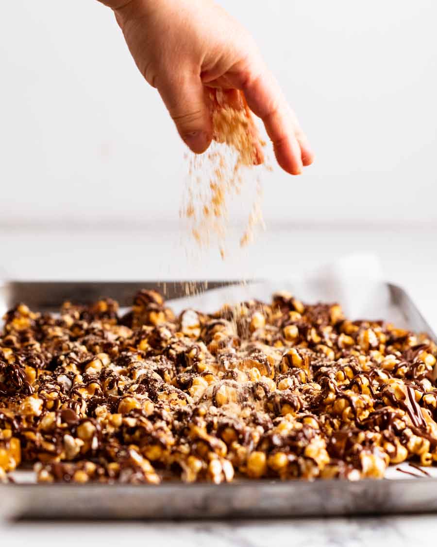 Sprinkling crumbs on Golden Gaytime popcorn - copycat recipe