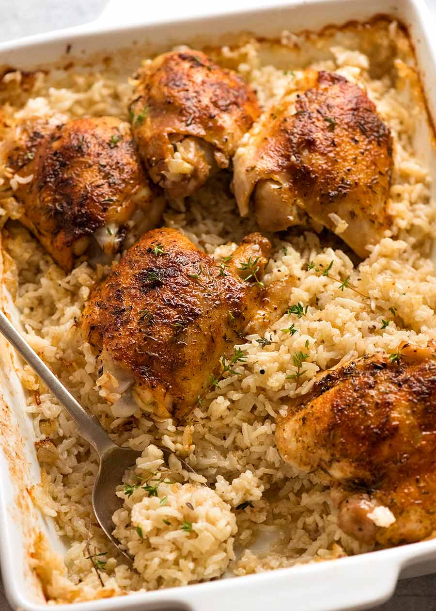 White baking dish with Oven Baked Chicken and Rice, ready to be served