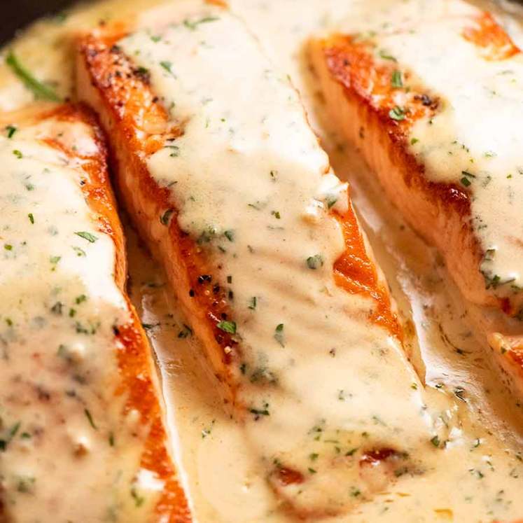 Close up of Creamy Herb & Garlic Salmon Sauce in a skillet, fresh off the stove